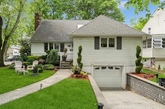 18 Hawthorne Ln, Valley Stream, NY 11581 - view of front of property with roof with shingles, a chimney, an attached garage, decorative driveway, and a front yard
