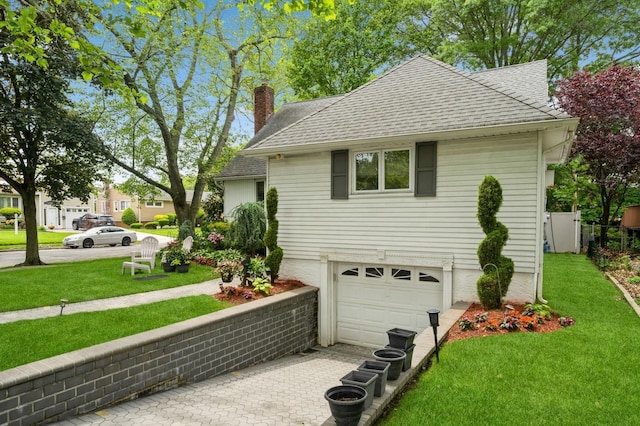 18 Hawthorne Ln, Valley Stream, NY 11581 - view of side of home featuring a shingled roof, a chimney, an attached garage, and a yard