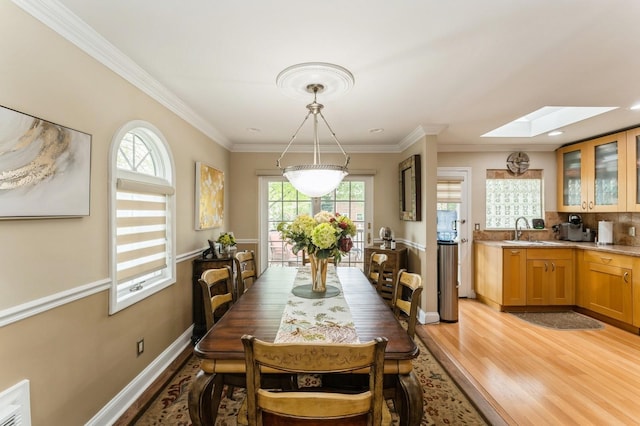 18 Hawthorne Ln, Valley Stream, NY 11581 - dining area featuring a skylight, light wood finished floors, plenty of natural light, baseboards, and ornamental molding