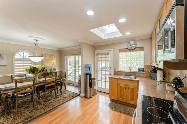 18 Hawthorne Ln, Valley Stream, NY 11581 - kitchen featuring a sink, a skylight, healthy amount of natural light, stainless steel microwave, and crown molding
