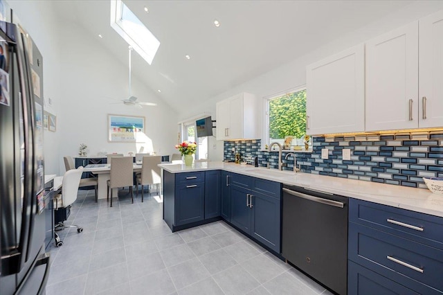 1270 Mara Ct, Atlantic Beach, NY 11509 - kitchen with stainless steel appliances, a sink, white cabinets, a skylight, and tasteful backsplash