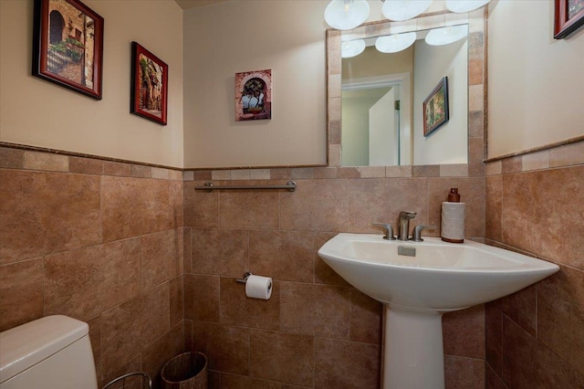 1270 Mara Ct, Atlantic Beach, NY 11509 - bathroom with tile walls, toilet, wainscoting, and a sink