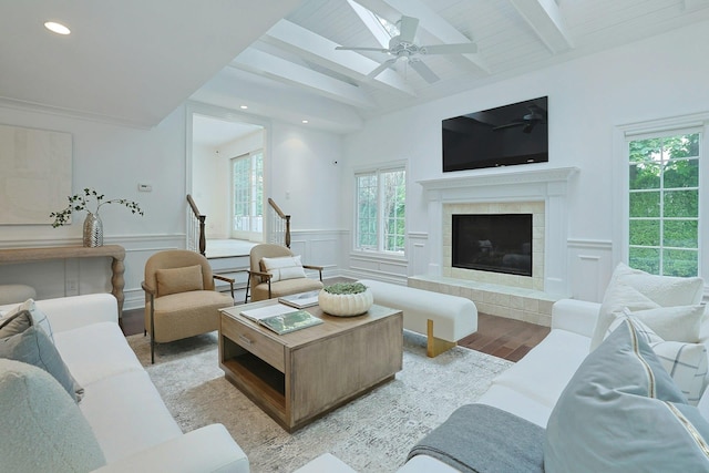 15 Old Farm Rd, Scarsdale, NY 10583 - living room featuring light wood-style flooring, a tile fireplace, beam ceiling, wainscoting, and ceiling fan