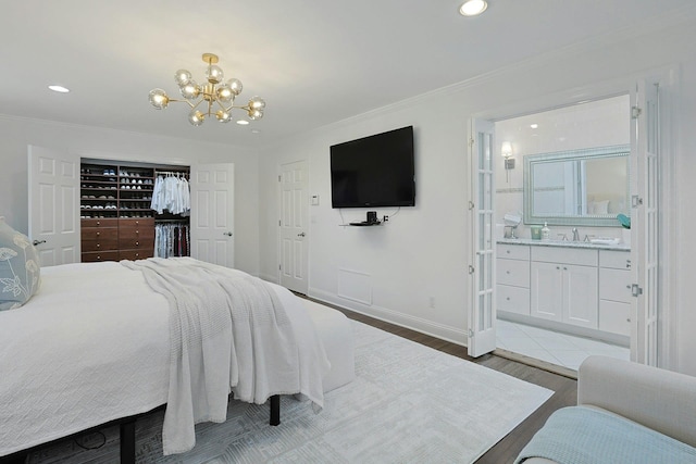 15 Old Farm Rd, Scarsdale, NY 10583 - bedroom with wood finished floors, a chandelier, connected bathroom, recessed lighting, and a sink