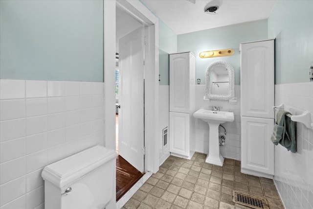 102 Broadway, Dobbs Ferry, NY 10522 - bathroom with tile walls, a wainscoted wall, and toilet