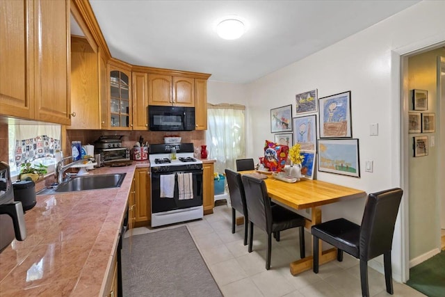102 Broadway, Dobbs Ferry, NY 10522 - kitchen featuring white gas range, black microwave, a sink, light countertops, and glass insert cabinets