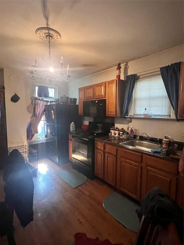 13 Hooker Ave, Poughkeepsie, NY 12601 - kitchen featuring black appliances, dark countertops, brown cabinets, a chandelier, and wood finished floors