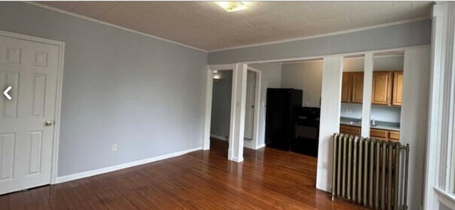 13 Hooker Ave, Poughkeepsie, NY 12601 - unfurnished living room featuring radiator, ornamental molding, and dark wood-type flooring