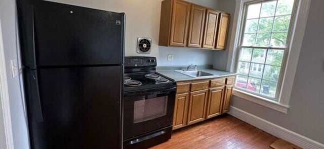 13 Hooker Ave, Poughkeepsie, NY 12601 - kitchen featuring black appliances, light wood-style floors, light countertops, and brown cabinets