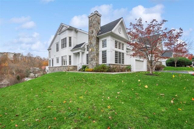 2 Shadow Tree Ln, Briarcliff Manor, NY 10510 - back of house featuring a garage, stone siding, a lawn, and a chimney