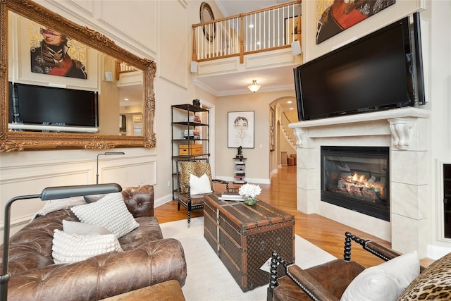 2 Shadow Tree Ln, Briarcliff Manor, NY 10510 - living area with arched walkways, light wood finished floors, a glass covered fireplace, ornamental molding, and a towering ceiling