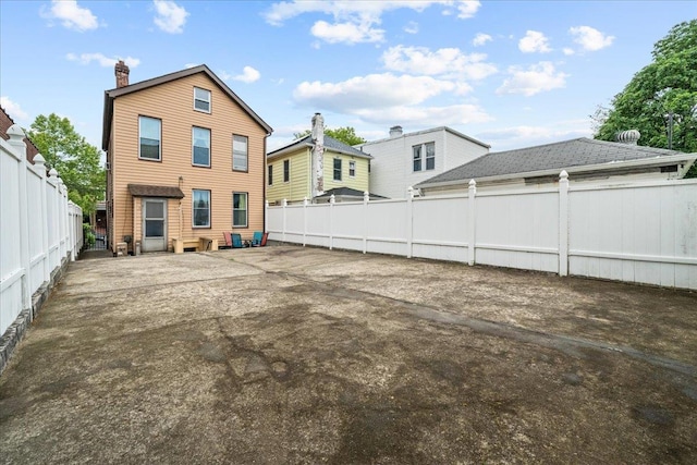 2140 Story Ave, Bronx, NY 10473 - back of property featuring a fenced backyard, a chimney, and a patio area