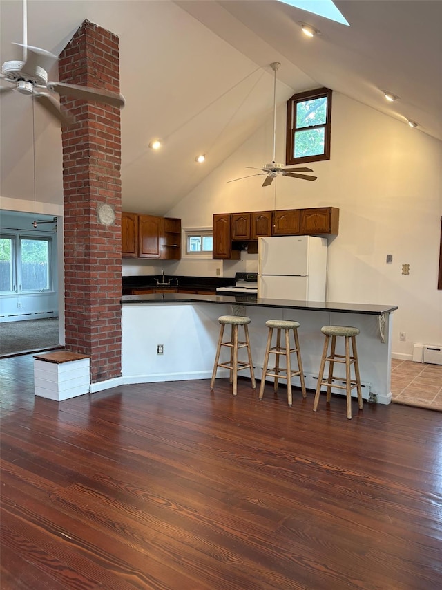 118 Truberg Ave, Patchogue, NY 11772 - kitchen featuring freestanding refrigerator, a ceiling fan, dark countertops, high vaulted ceiling, and a baseboard heating unit