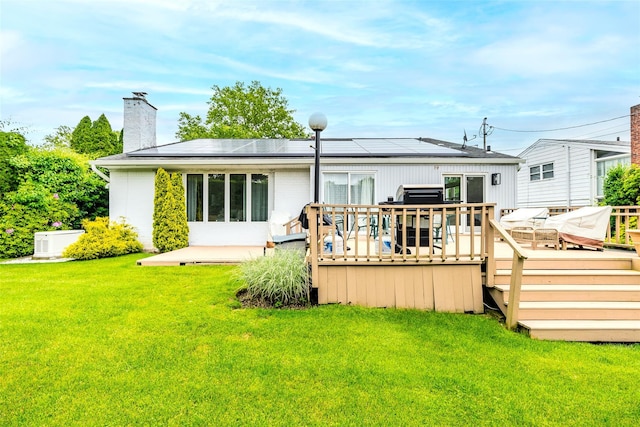 36 Randy Ln, Plainview, NY 11803 - back of property with a lawn, a chimney, a deck, and solar panels