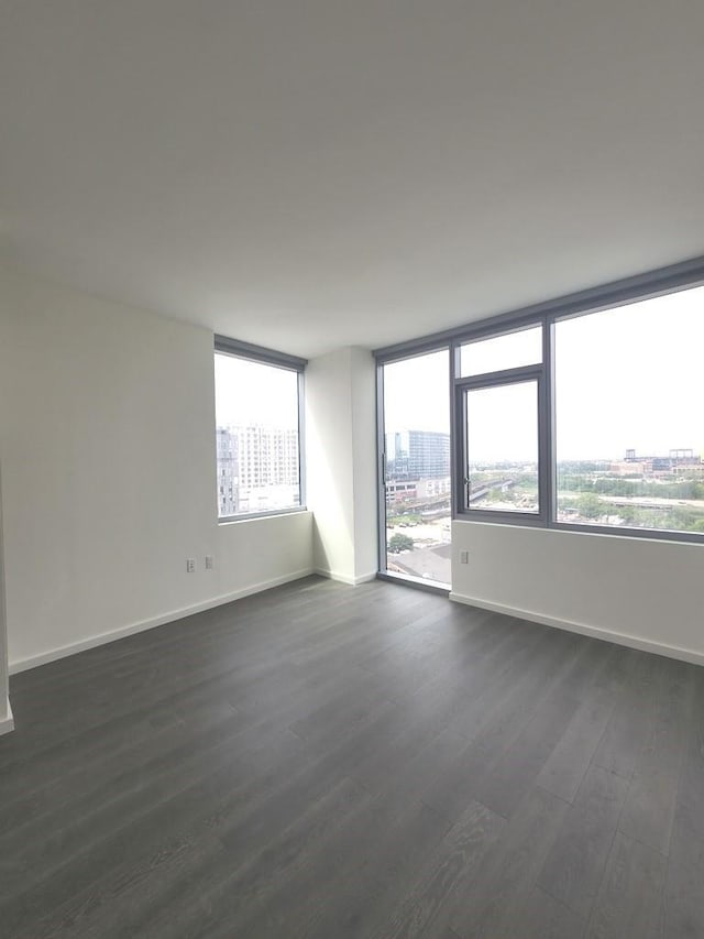 133-36 37th Ave Unit 8B, Flushing, NY 11354 - spare room featuring baseboards, dark wood finished floors, and a view of city