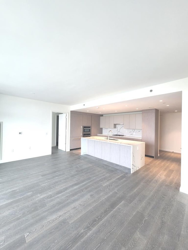 133-36 37th Ave Unit 8B, Flushing, NY 11354 - kitchen featuring gray cabinets, a sink, a spacious island, light wood-style floors, and light countertops