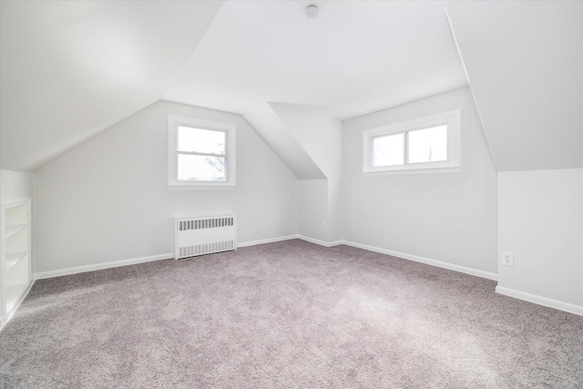 23 Lincoln St, Elmont, NY 11003 - additional living space with radiator heating unit, carpet floors, plenty of natural light, lofted ceiling, and baseboards