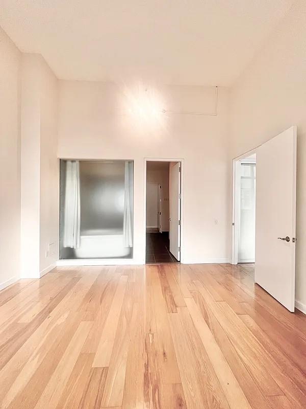 2728 Thomson Ave Unit 434, Long Island City, NY 11101 - empty room featuring light wood finished floors and baseboards