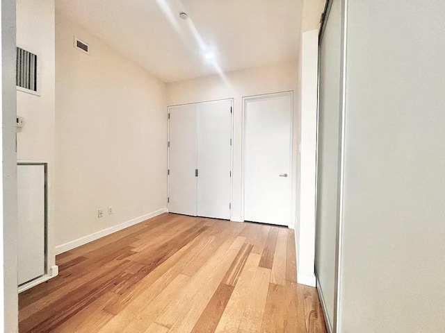 2728 Thomson Ave Unit 434, Long Island City, NY 11101 - unfurnished bedroom with light wood-type flooring, baseboards, and two closets