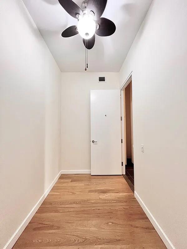 2728 Thomson Ave Unit 434, Long Island City, NY 11101 - empty room featuring ceiling fan, light wood finished floors, and baseboards