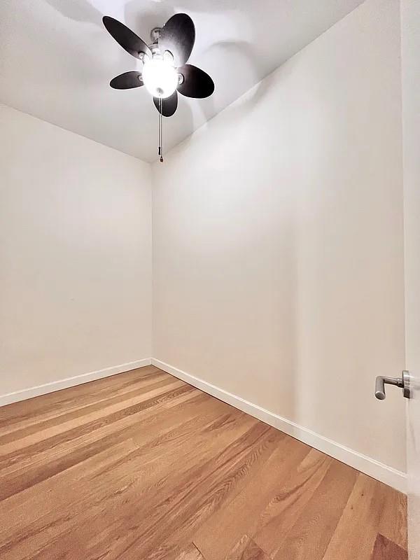 2728 Thomson Ave Unit 434, Long Island City, NY 11101 - spare room with light wood-style flooring, baseboards, and a ceiling fan