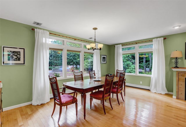 23 Knox Ave, Stony Brook, NY 11790 - dining area with a chandelier, baseboard heating, light wood finished floors, and baseboards