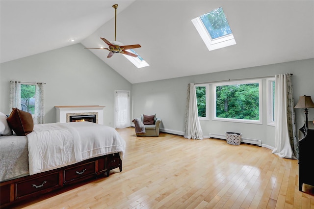 23 Knox Ave, Stony Brook, NY 11790 - bedroom featuring a skylight, light wood-style floors, high vaulted ceiling, and baseboard heating