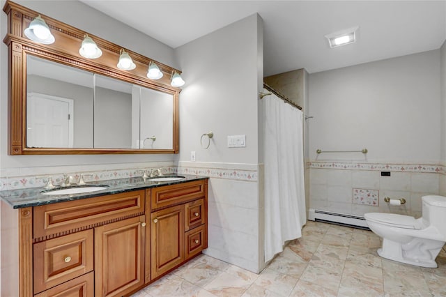 23 Knox Ave, Stony Brook, NY 11790 - full bathroom featuring tile walls, baseboard heating, wainscoting, toilet, and double vanity
