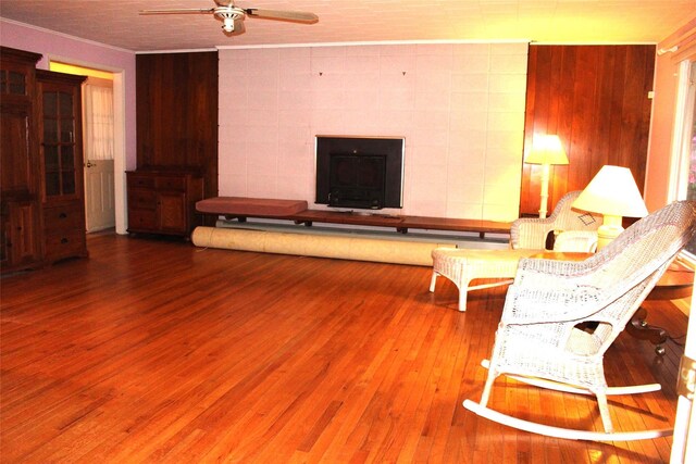 113 Pine Neck Ave, East Patchogue, NY 11772 - living area with ceiling fan, wood finished floors, a tile fireplace, crown molding, and wooden walls