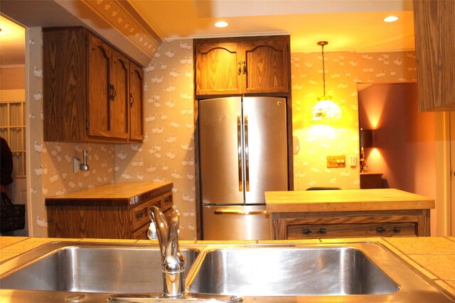 113 Pine Neck Ave, East Patchogue, NY 11772 - kitchen with wallpapered walls, freestanding refrigerator, brown cabinets, tile countertops, and recessed lighting