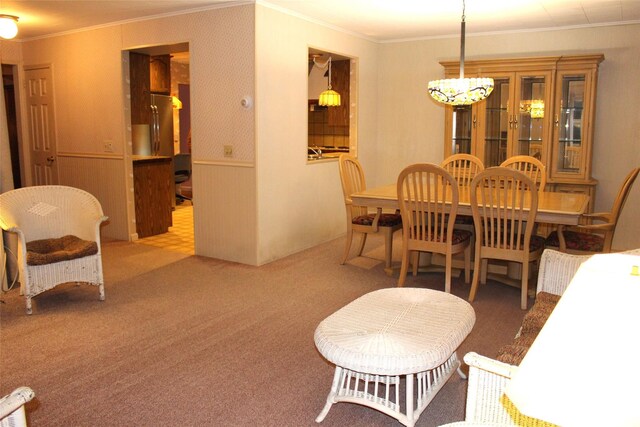 113 Pine Neck Ave, East Patchogue, NY 11772 - carpeted dining area featuring ornamental molding, a chandelier, and a wainscoted wall