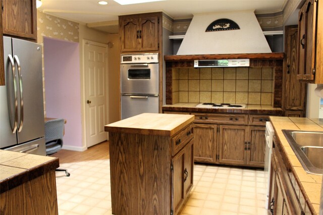 113 Pine Neck Ave, East Patchogue, NY 11772 - kitchen with appliances with stainless steel finishes, light floors, butcher block countertops, a center island, and recessed lighting