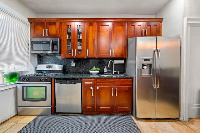 34-15 91st St, Jackson Heights, NY 11372 - kitchen featuring appliances with stainless steel finishes, a sink, backsplash, glass insert cabinets, and dark stone countertops