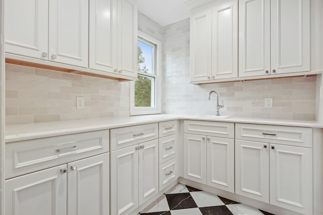 158 Loring Ave, Pelham, NY 10803 - kitchen featuring a sink, white cabinets, light countertops, and decorative backsplash