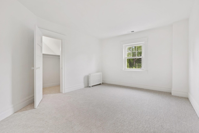 158 Loring Ave, Pelham, NY 10803 - unfurnished bedroom with radiator heating unit, carpet floors, a walk in closet, and baseboards