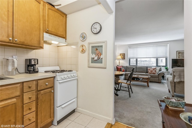 35 Stewart Pl Unit 302, Mount Kisco, NY 10549 - kitchen featuring under cabinet range hood, white range with gas cooktop, decorative backsplash, and open floor plan