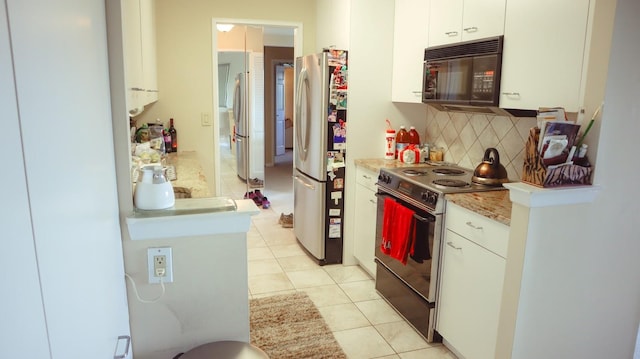 200 High Point Dr Unit 302, Hartsdale, NY 10530 - kitchen featuring black microwave, range with electric cooktop, freestanding refrigerator, decorative backsplash, and light tile patterned floors