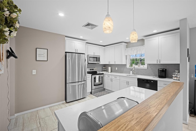 7 Pilgrim Ln, Washingtonville, NY 10992 - kitchen featuring stainless steel appliances, a sink, baseboards, backsplash, and pendant lighting