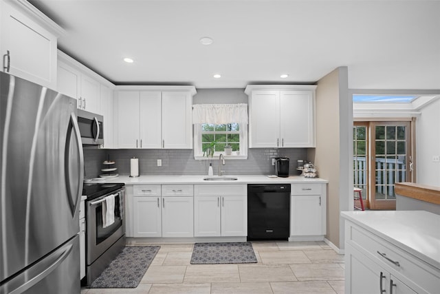 7 Pilgrim Ln, Washingtonville, NY 10992 - kitchen with stainless steel appliances, a sink, backsplash, light countertops, and white cabinetry
