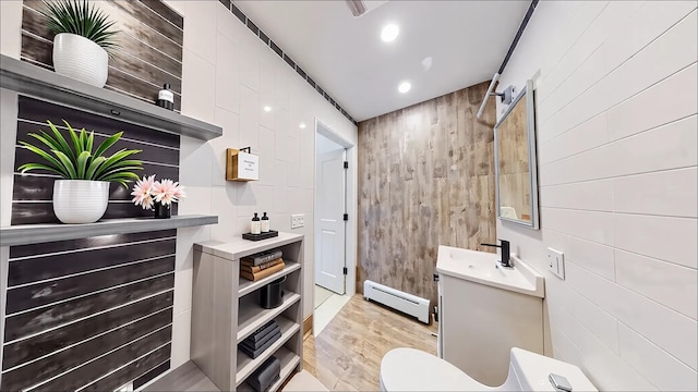 7252 Metropolitan Ave Unit 2B, Middle Village, NY 11379 - bathroom featuring baseboard heating, vanity, wood walls, wood finished floors, and recessed lighting