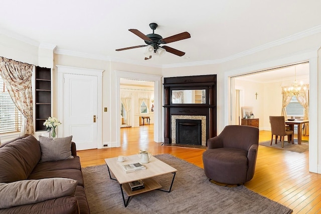 57 Maple Ave, Bay Shore, NY 11706 - living area featuring a chandelier, wood finished floors, ornamental molding, ceiling fan, and a fireplace with flush hearth