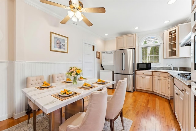 57 Maple Ave, Bay Shore, NY 11706 - kitchen with stainless steel appliances, stacked washing machine and dryer, a sink, crown molding, and light countertops