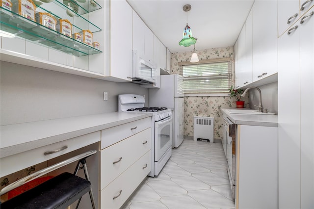 82-25 268th St Unit 175B, New Hyde Park, NY 11004 - kitchen with white appliances, radiator heating unit, light countertops, white cabinetry, and wallpapered walls