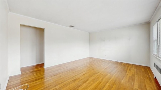 29 Melanie Ln, Syosset, NY 11791 - spare room featuring light wood-style flooring, crown molding, radiator, and baseboards