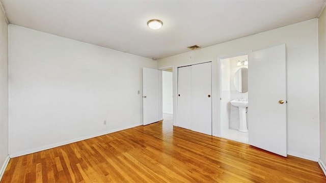 29 Melanie Ln, Syosset, NY 11791 - unfurnished bedroom with light wood finished floors, ensuite bathroom, baseboards, and a closet