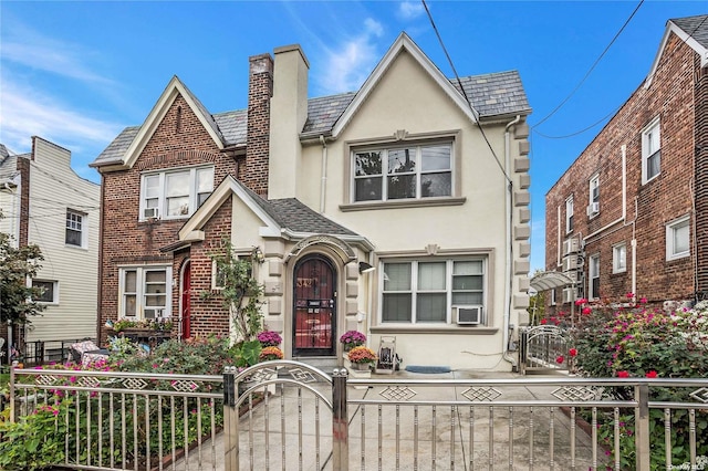 53-42 63rd St, Maspeth, NY 11378 - tudor house with stucco siding, a fenced front yard, a gate, a chimney, and cooling unit