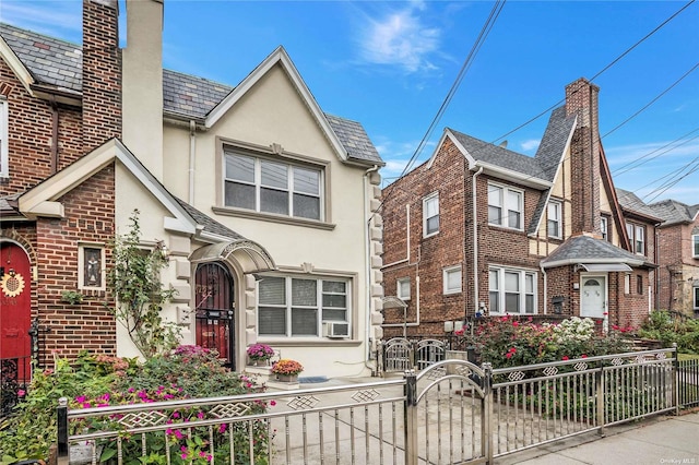 53-42 63rd St, Maspeth, NY 11378 - tudor home featuring stucco siding, a chimney, cooling unit, and a gate