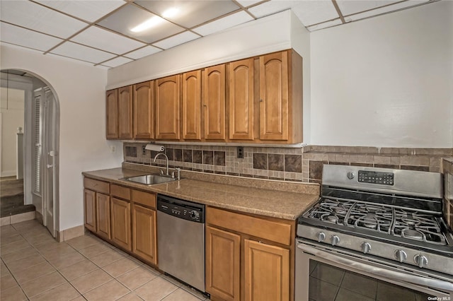 53-42 63rd St, Maspeth, NY 11378 - kitchen with appliances with stainless steel finishes, a sink, arched walkways, backsplash, and brown cabinetry