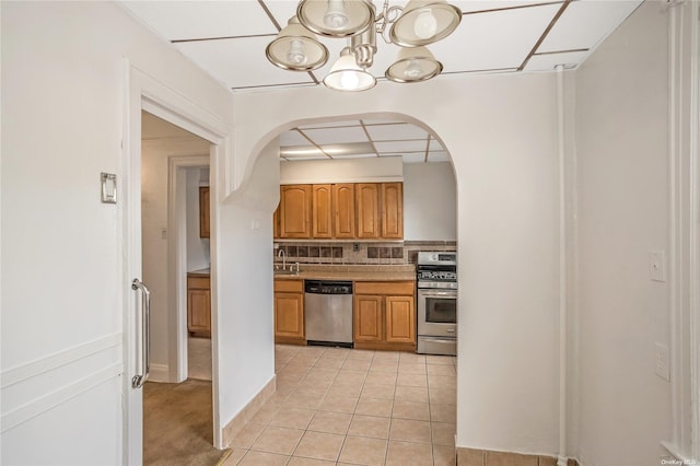53-42 63rd St, Maspeth, NY 11378 - kitchen with stainless steel appliances, arched walkways, a chandelier, a sink, and light tile patterned floors