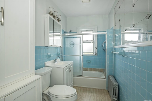 53-42 63rd St, Maspeth, NY 11378 - full bath featuring radiator heating unit, tile walls, toilet, combined bath / shower with glass door, and vanity